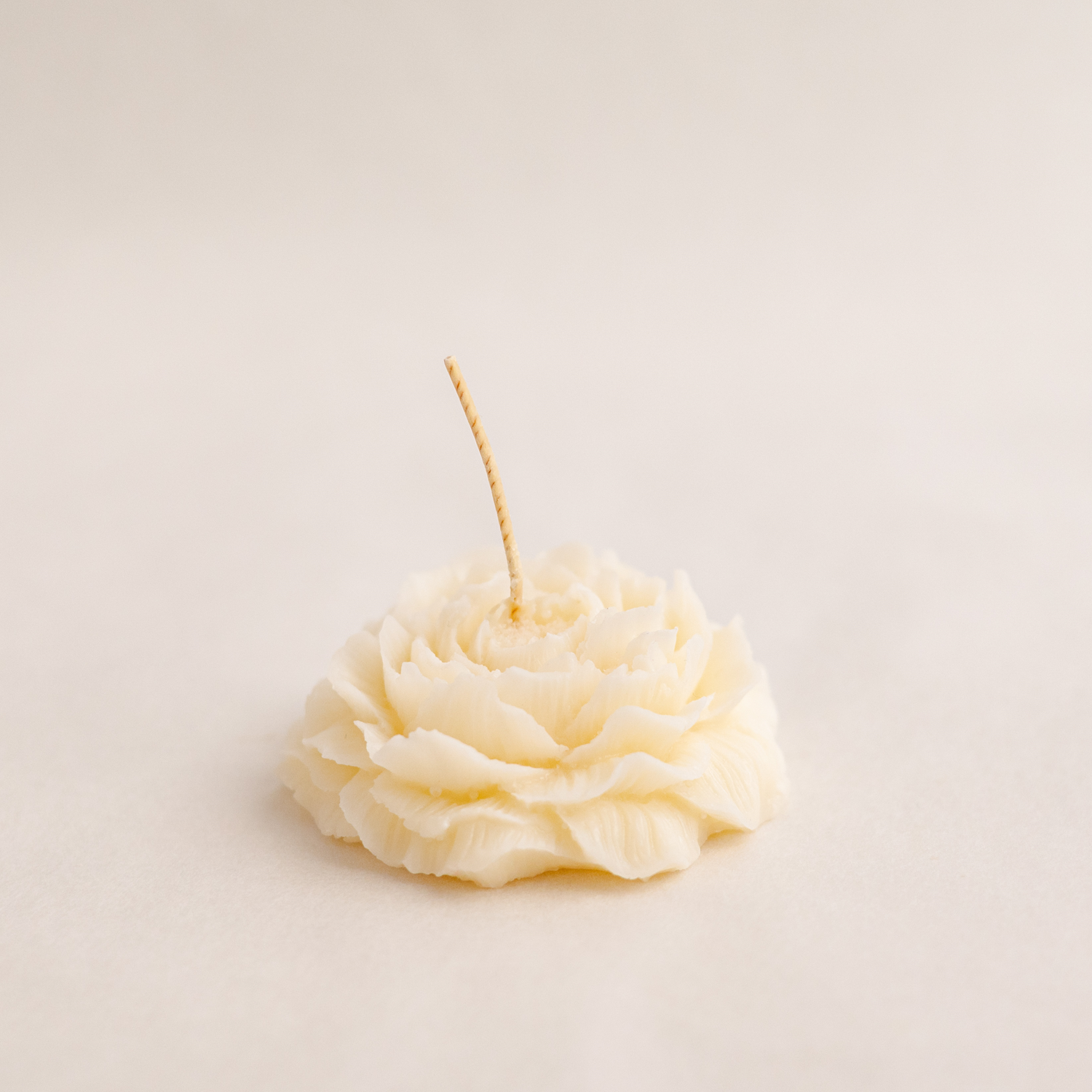 Handmade peony candle made of soy wax in colour ivory with a lead-free wick. Customization options available for decorative candles in UAE at minoocandles dot com