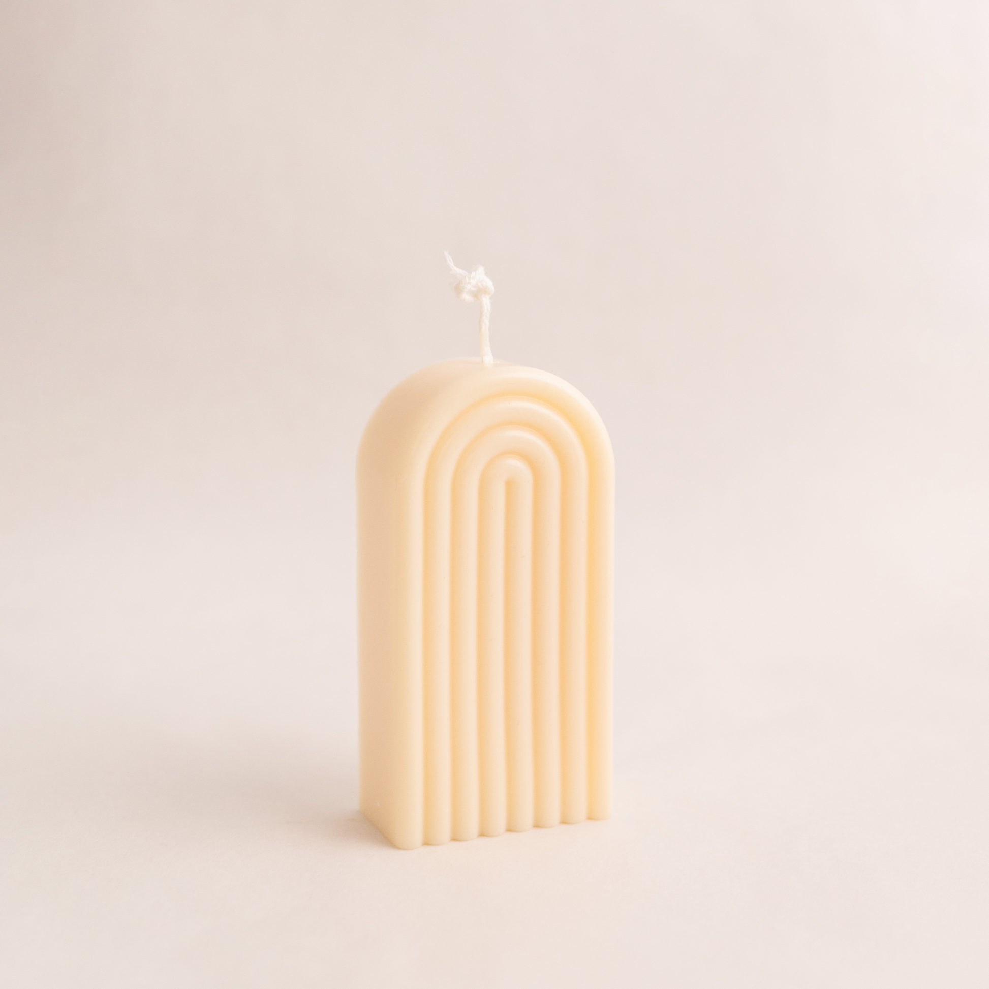 Handmade rainbow arch pillar candle made of soy wax in colour ivory with a lead-free wick. Customization options available for decorative candles in UAE at minoocandles dot com