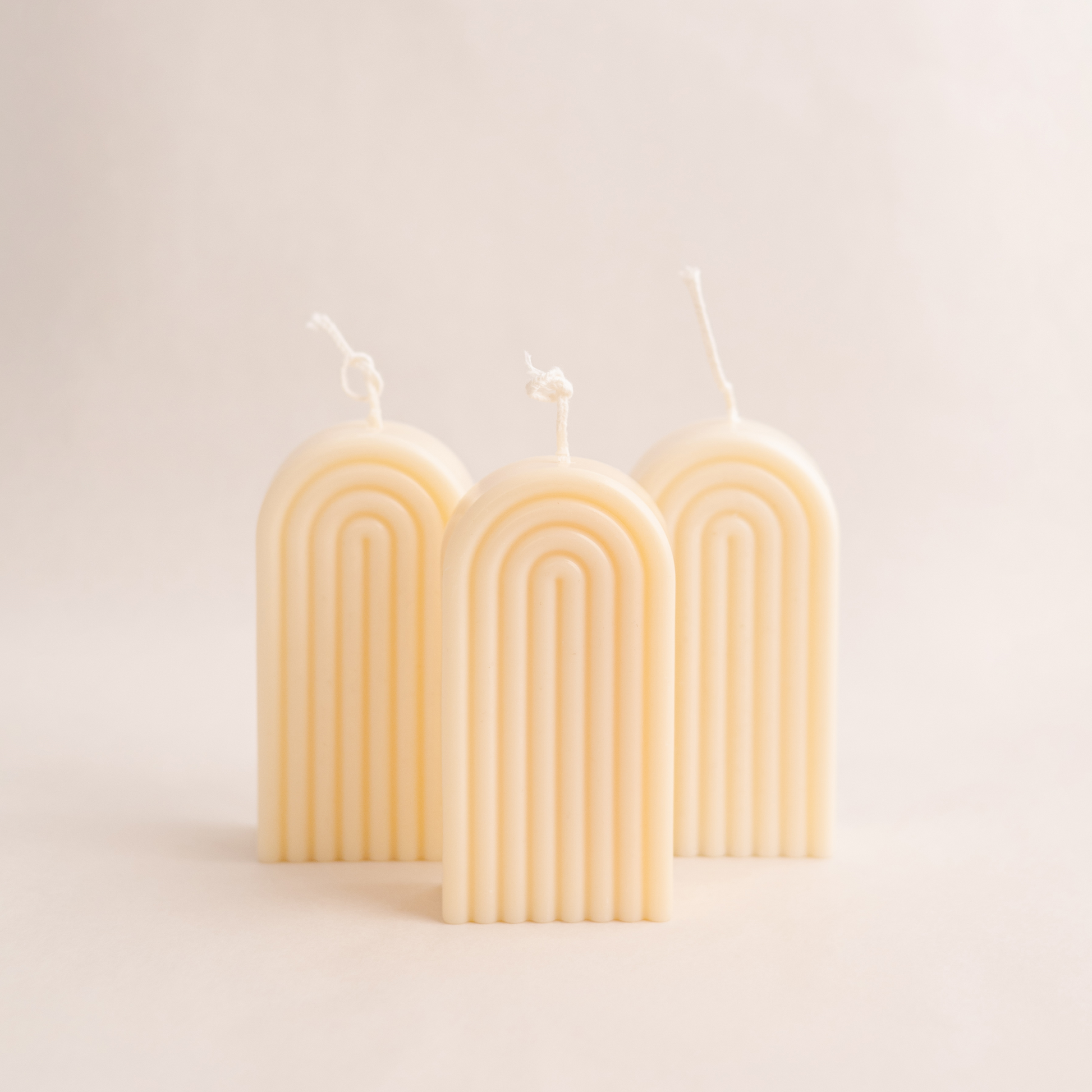 Handmade rainbow arch pillar candle made of soy wax in colour ivory with a lead-free wick. Customization options available for decorative candles in UAE at minoocandles dot com