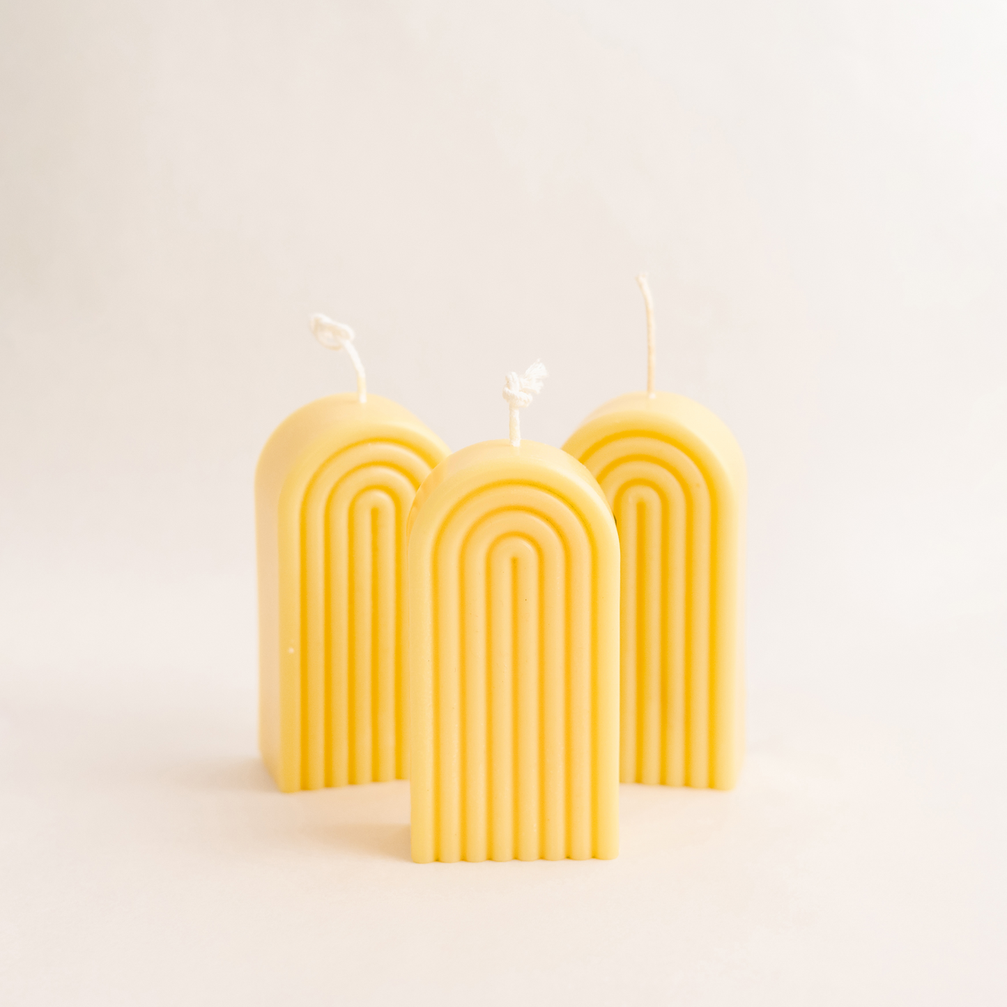 three handmade rainbow arch candle made of soy wax in colour yellow with a lead-free wick. Customization options available for decorative candles in UAE at minoocandles dot com