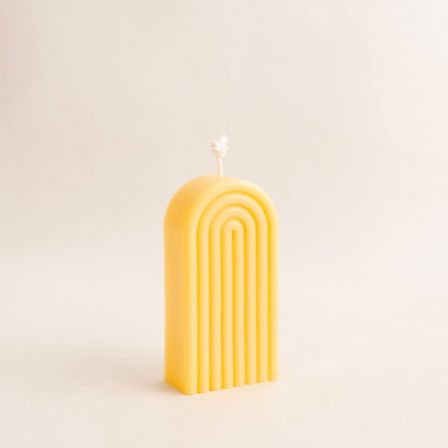 Handmade rainbow arch pillar candle made of soy wax in colour yellow with a lead-free wick. Customization options available for decorative candles in UAE at minoocandles dot com