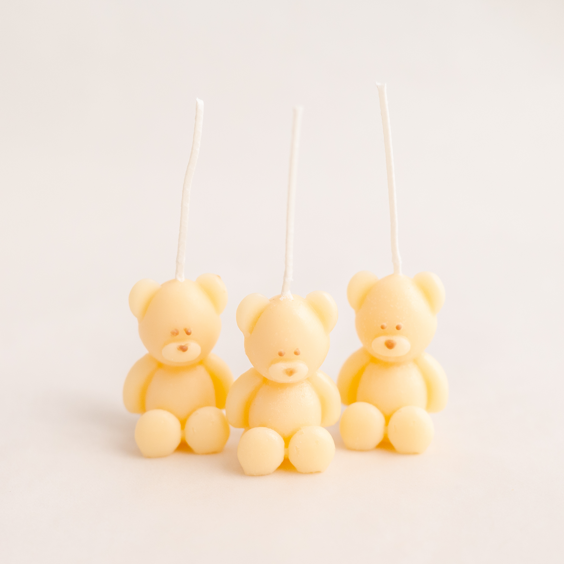 Three cute kawaii handmade bear candles made of soy wax in colour ivory with a lead-free wick. Customization options available for decorative candles in UAE at minoocandles dot com